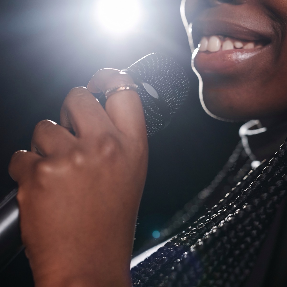 A singer with the microphone in the light